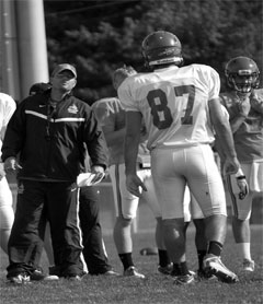 Football Coach Matt Walker and junior tight end Jon Manke exchange a look